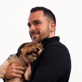Josh Popkin, former stand-up comedian and marketing engineer, holding his dog