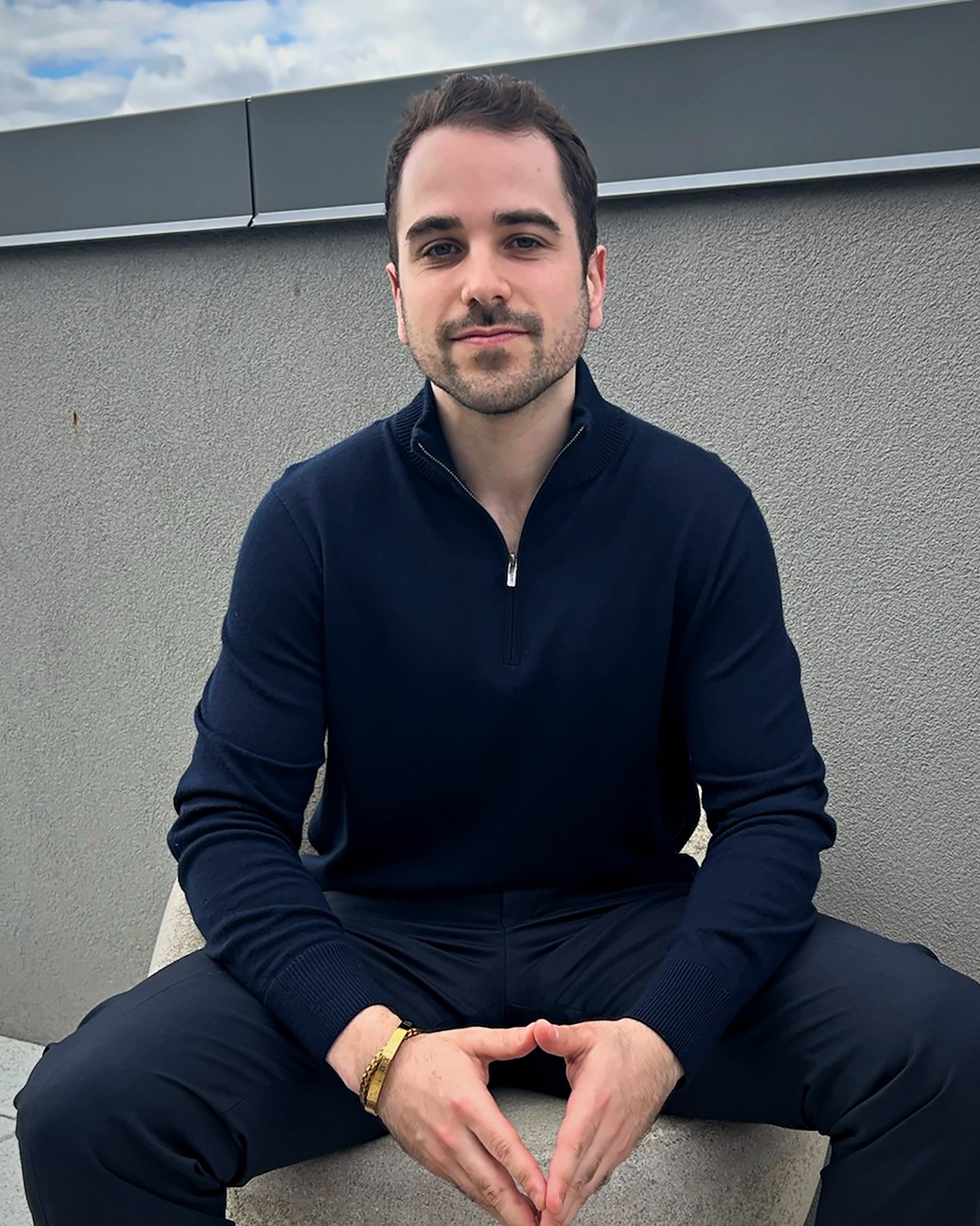 Josh Popkin, marketing engineer, seated against a gray wall in New York City, 2026